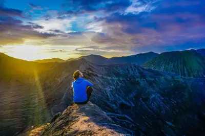 Wisatawan menikmati sunrise Bromo sendirian di tepi kawah — pengalaman yang bisa didapat via open trip maupun private trip
