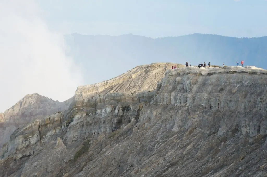 Wisatawan beristirahat saat turun dari Kawah Ijen