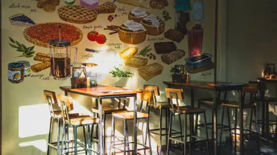 Interior kafe estetik dengan cahaya hangat, mural, dan kursi kayu, suasana nongkrong khas kafe hits Malang