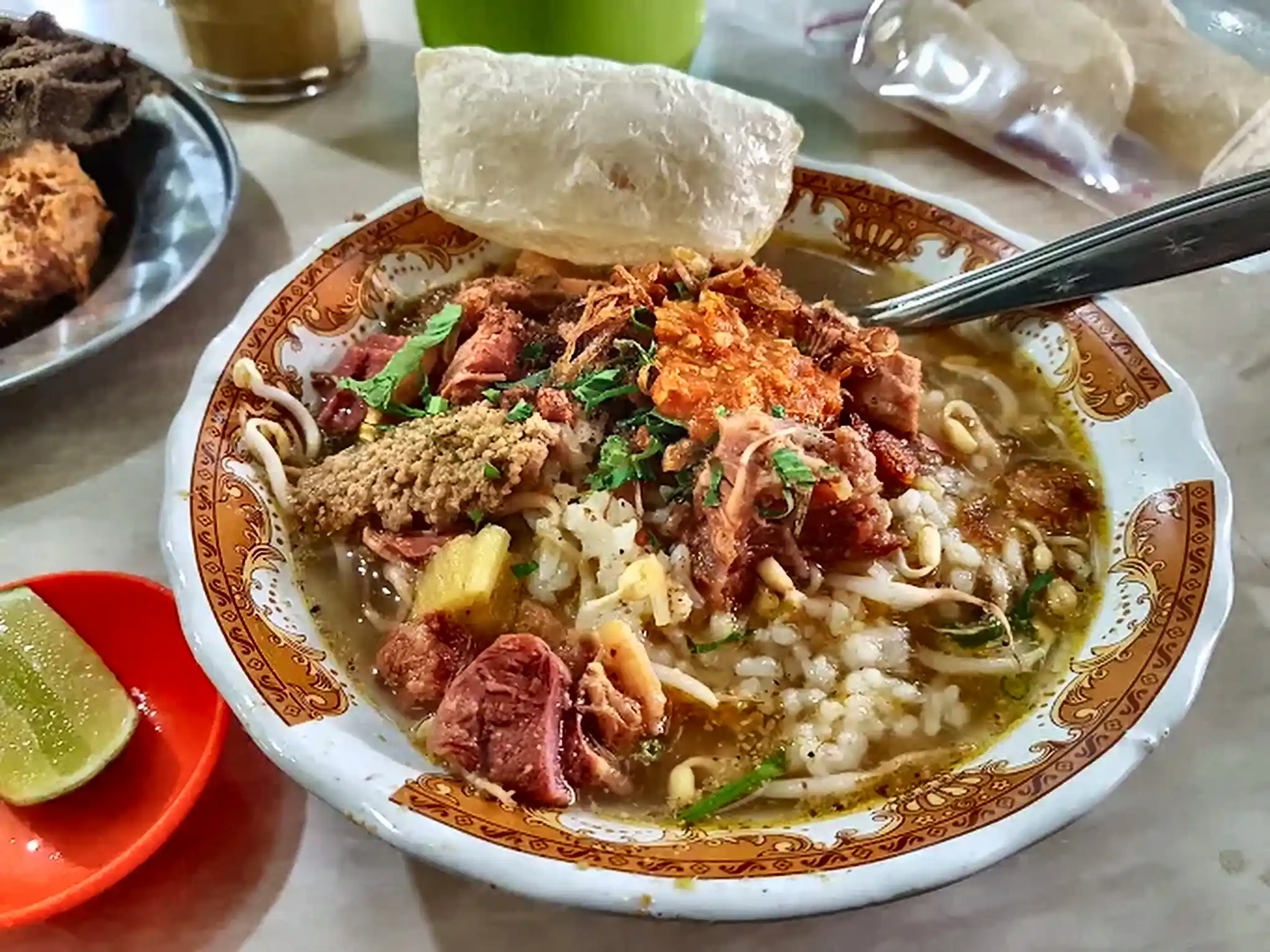 Soto khas Malang berkuah bening kekuningan dengan taburan koya dan kerupuk